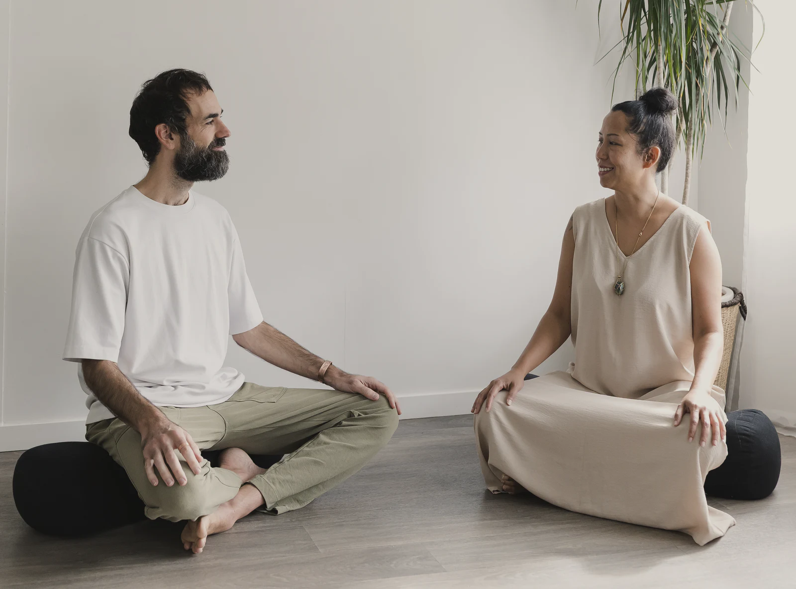 Nic Robertson and Vanessa Fernandez sitting cross-legged, facing each other